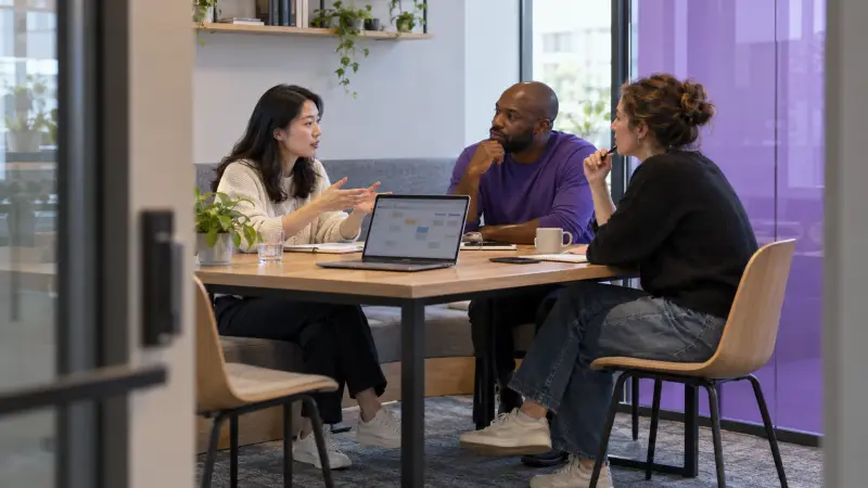 Colleagues clarify a software project handover during a small work discussion.